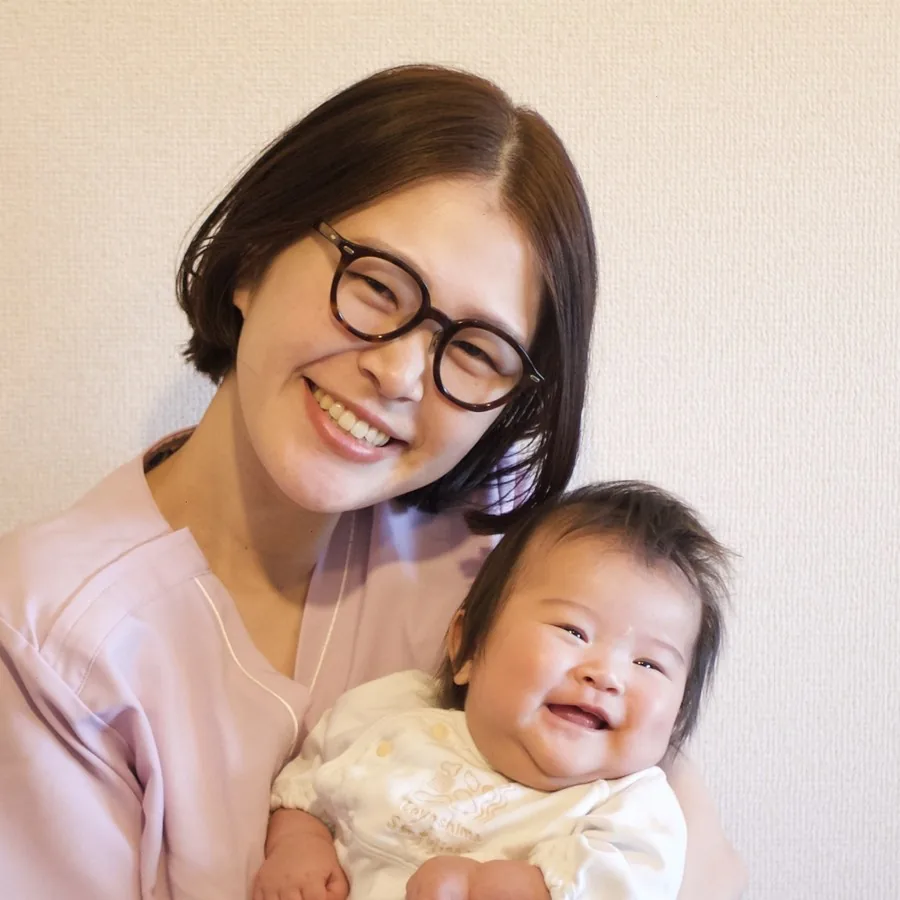 国家資格を持つ助産師が笑顔で赤ちゃんを抱く様子