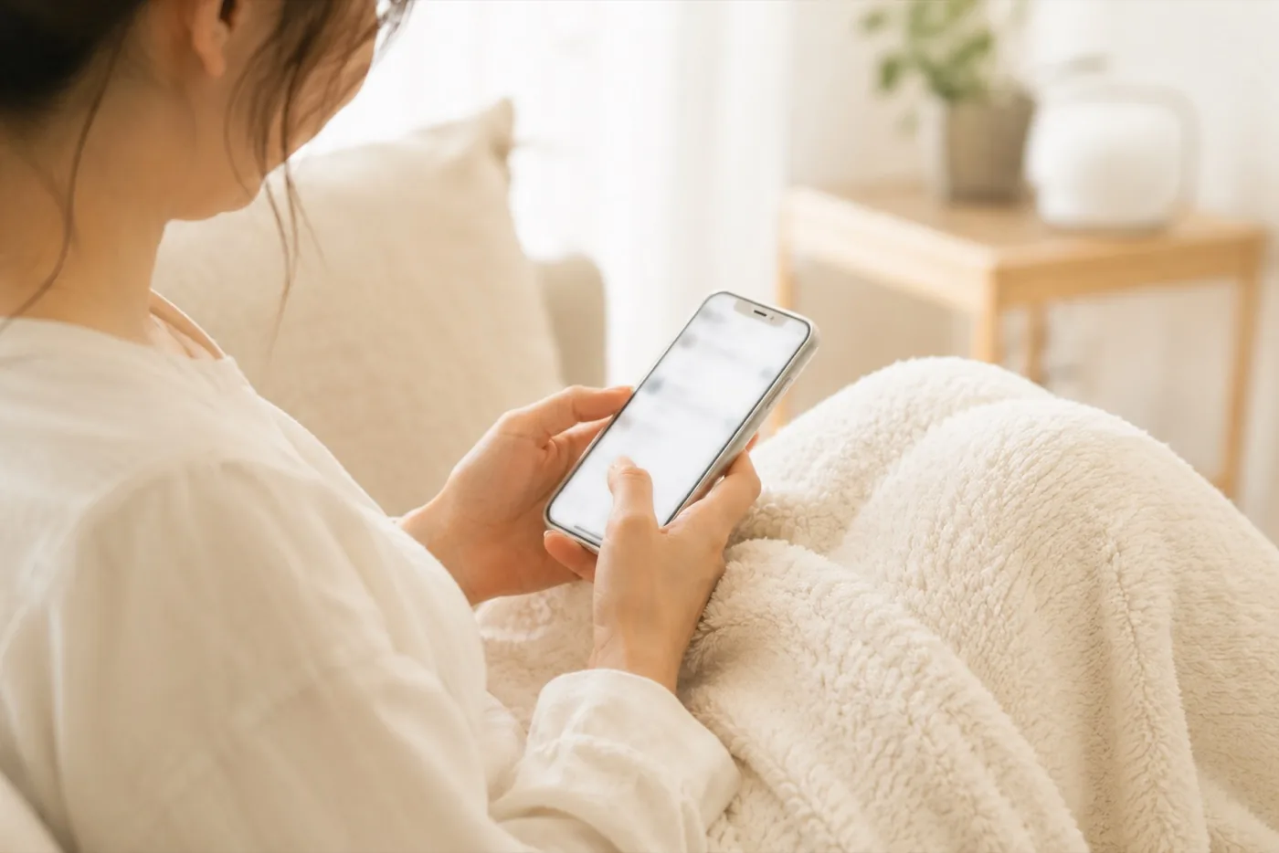 ソファでスマートフォンからLINEでやり取りする様子