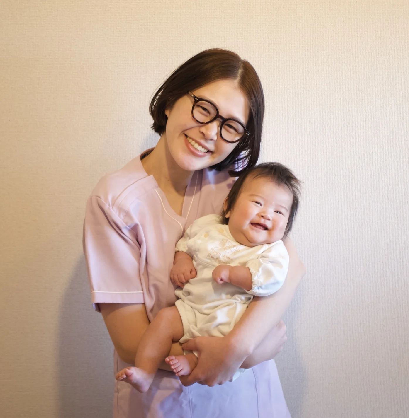 赤ちゃんを抱いて笑顔で寄り添う代表