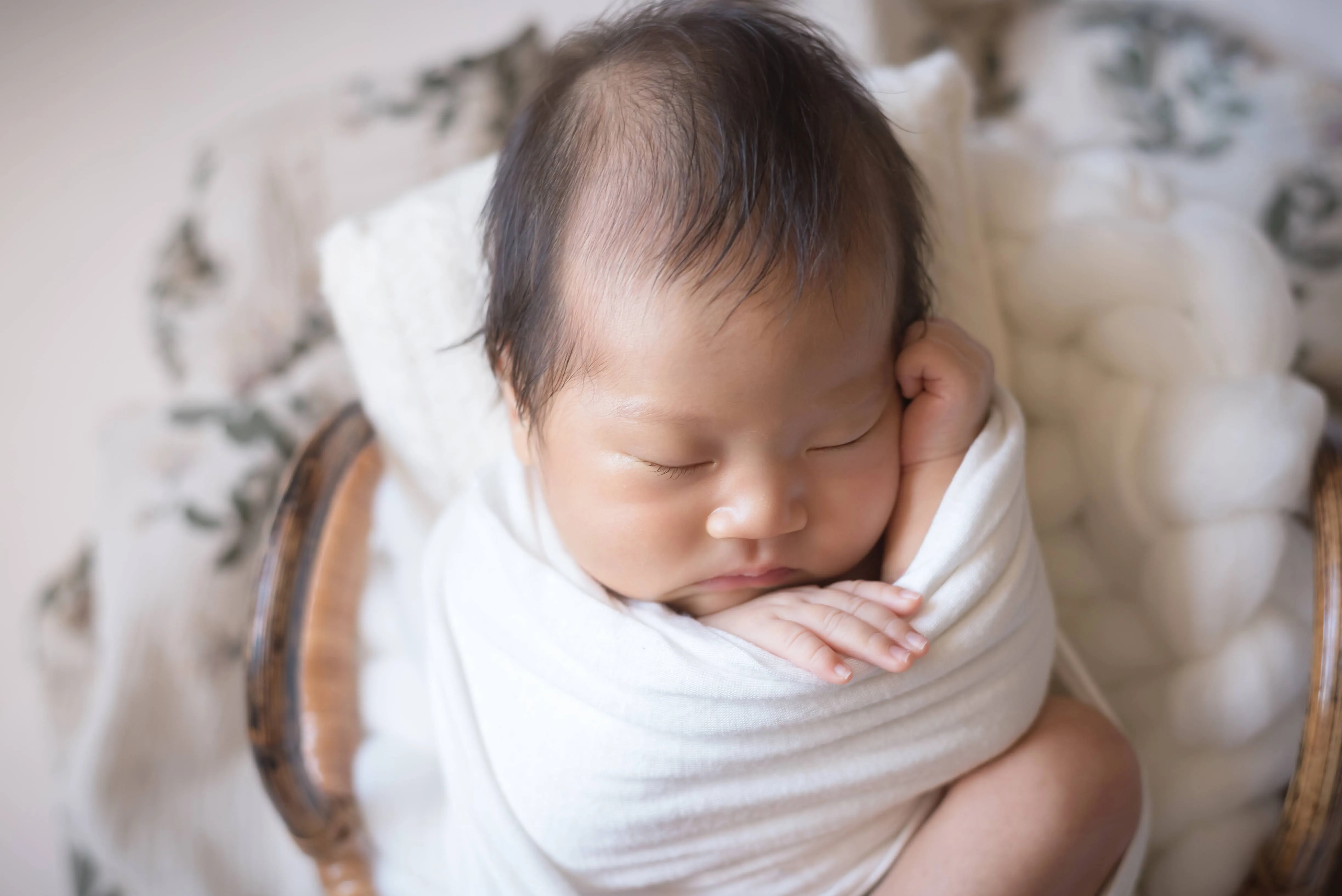やわらかな毛布に包まれて眠る赤ちゃん